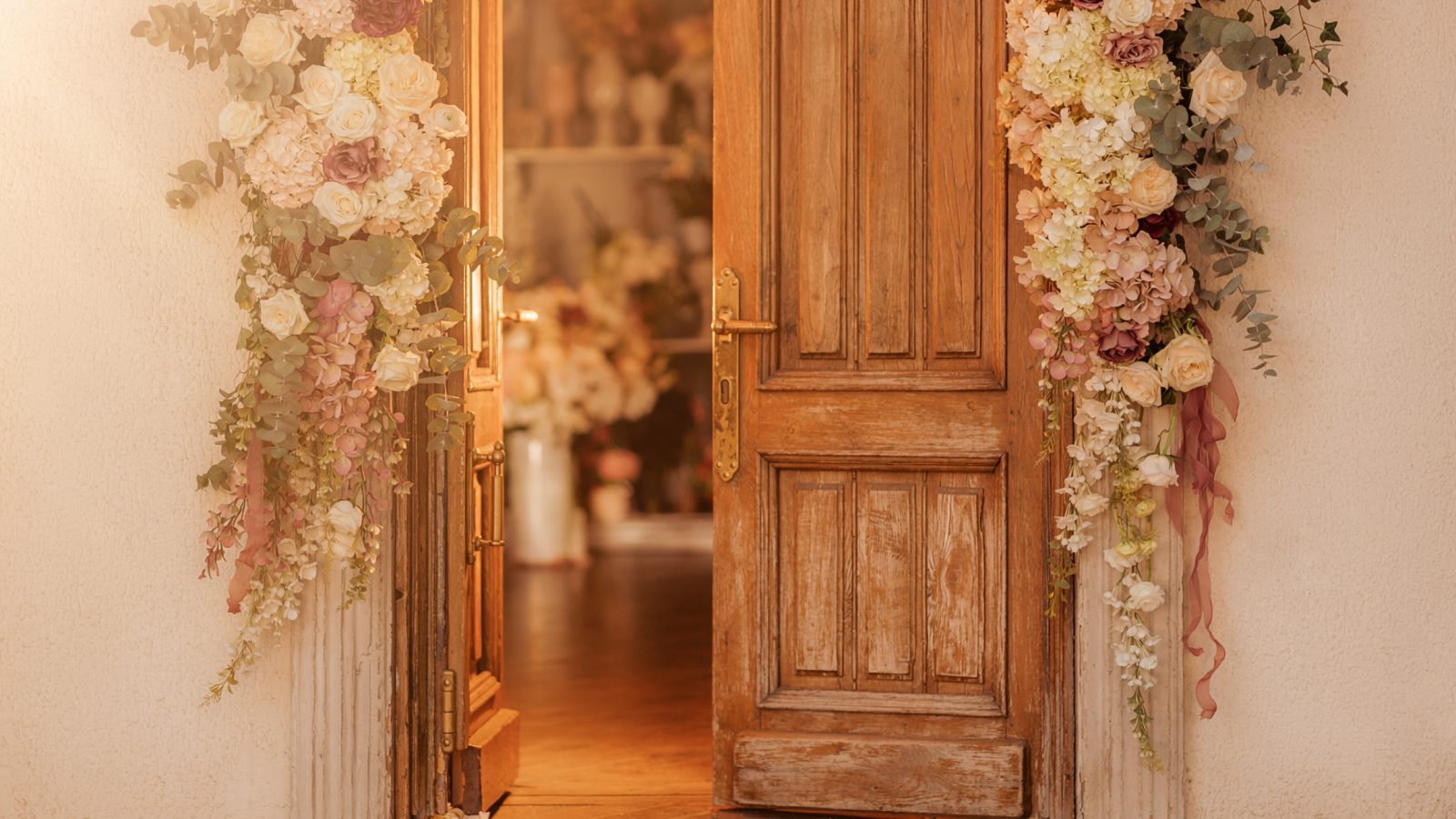 Einladend geöffnete Tür eines kleinen Hochzeitsateliers mit Blumen am Eingang