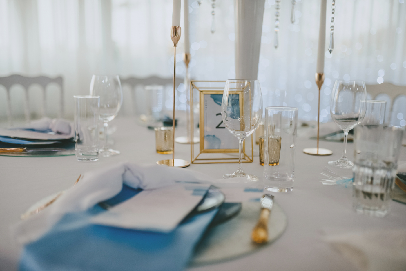 Elegante Hochzeitstischdekoration mit goldenen Akzenten, Kerzen und dékorativen Details für eine stilvolle Hochzeitsfeier.