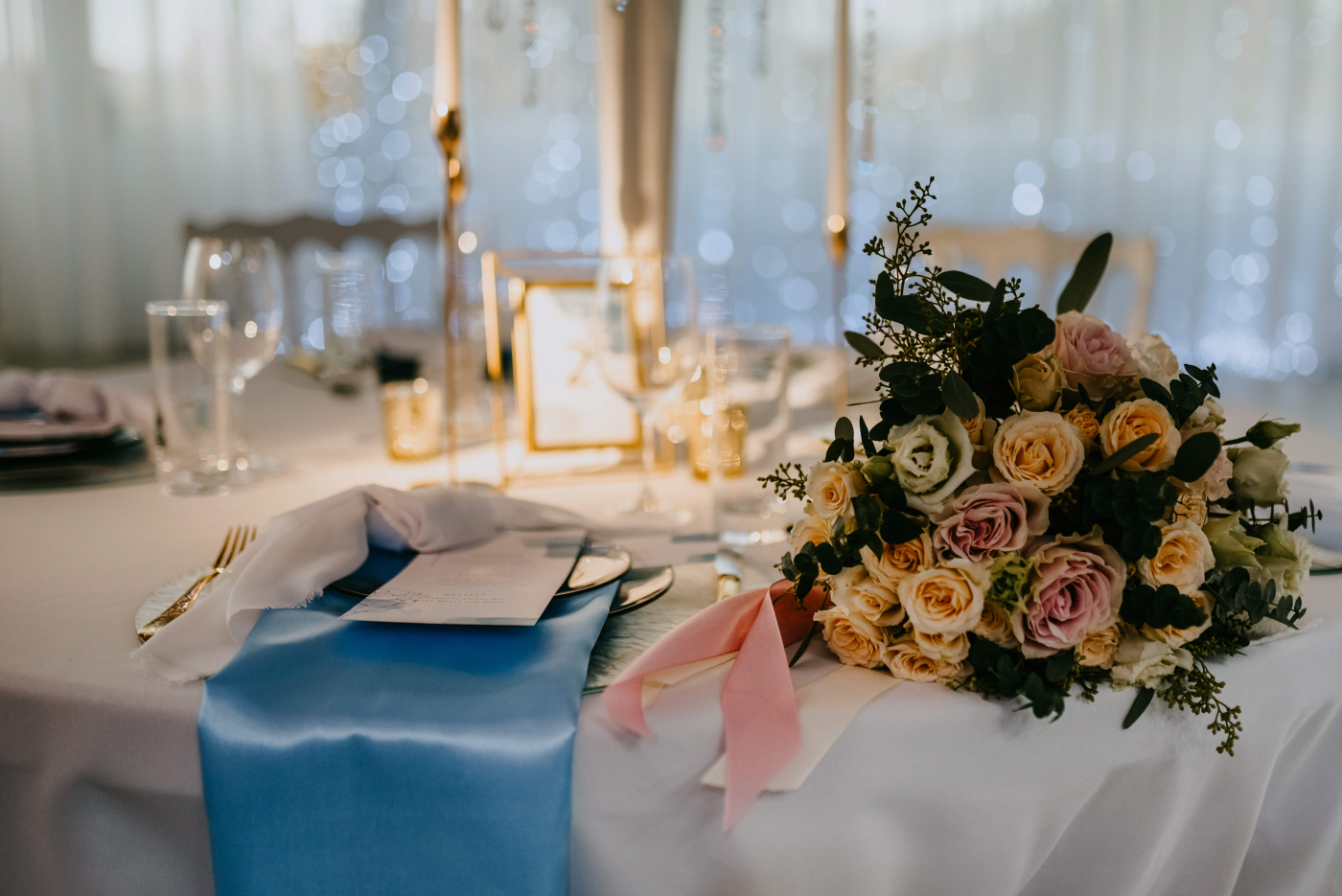 Ein mit Blumen und Kerzen dekorierter Empfangstisch für eine elegante Hochzeitsfeier.
