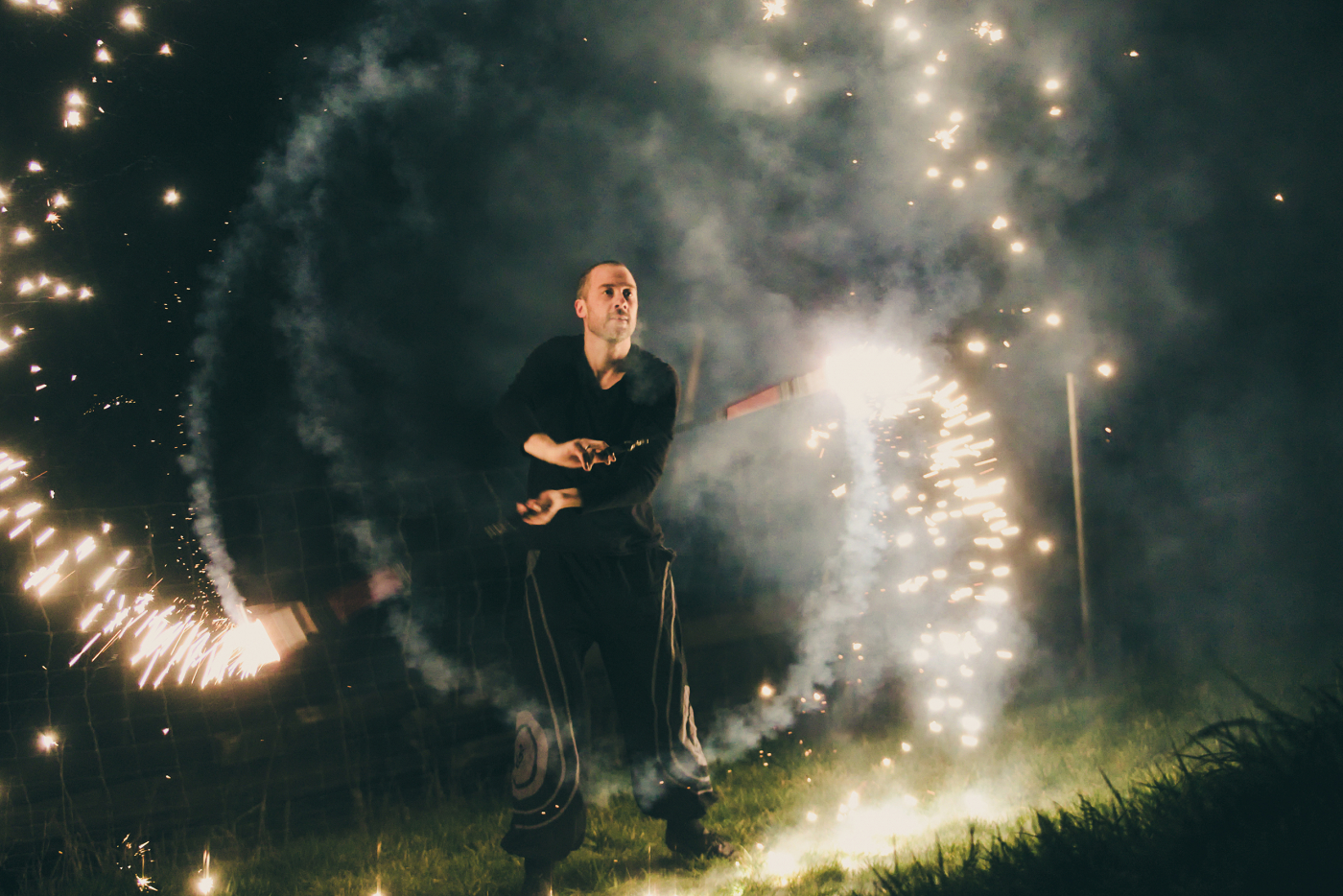 Feuershow bei einer Hochzeitsfeier, funkelnde Feuerwerkslichter im Hintergrund, Outdoor-Hochzeitsdekoration