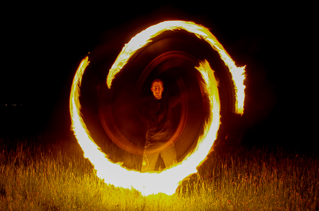 Hochzeitsfotografie einer Feuershow im Freien bei Nacht, die eine Hochzeitsfeier mit beeindruckender Hochzeitsdekoration ergänzt.