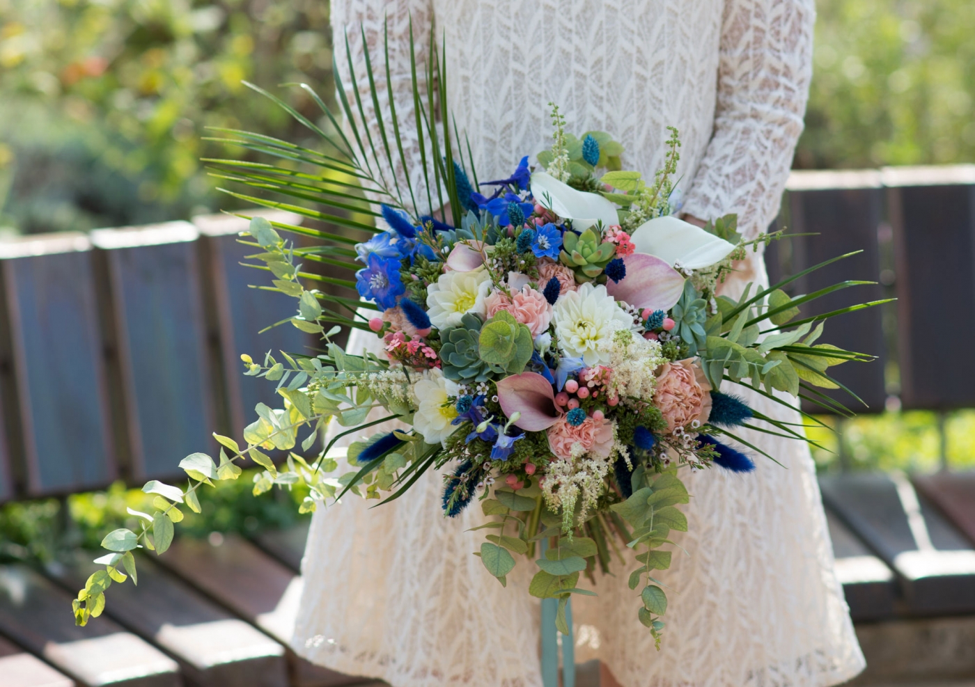 Ein schöner Blumenstrauß wird von der Braut in einem eleganten Hochzeitskleid bei ihrer Sommerttrauung gehalten.