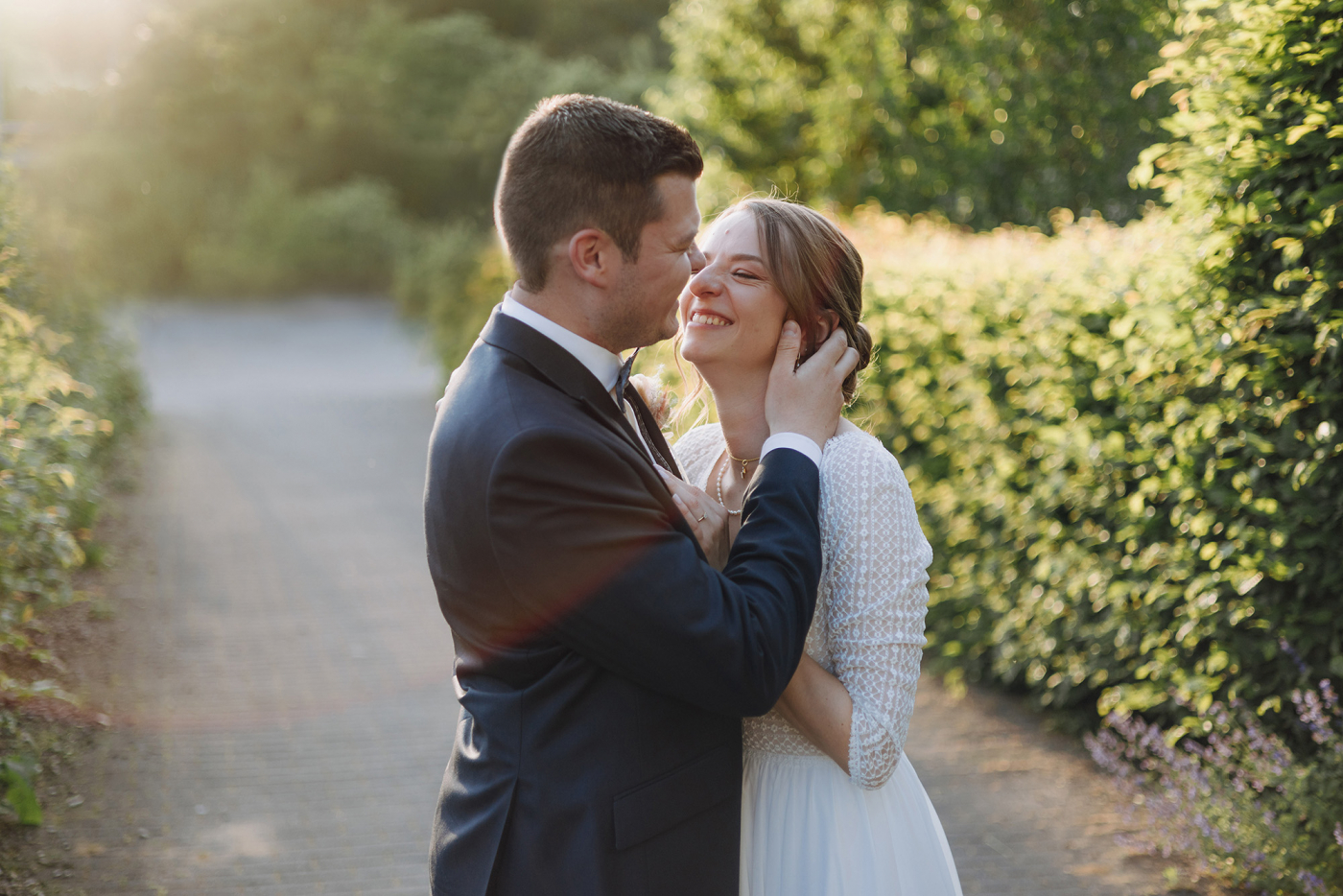 Braut und Bräutigam genießen einen romantischen Moment im Garten während ihrer Hochzeit, umgeben von üppigem Grün.